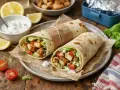 Deux wraps poulet savoureux, garnis de poulet croustillant, salade et tomates, prêts à être dégustés. Une recette wrap poulet facile et rapide.