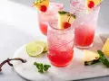 Orzeźwiający drink z ginem, ozdobiony ananasem i wiśnią, z dodatkiem limonki i mięty. Idealny na letnie popołudnie.