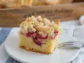 Ein Stück Kirsch-Streuselkuchen, perfekt für ein einfaches Crumble Rezept. Saftige Kirschen unter knusprigen Streuseln.