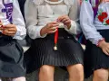 Trzy dziewczynki w szkolnych strojach, jedna trzyma dzwoneczek na wstążce. Czy w klasie 1-3 są świadectwa z paskiem?