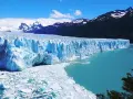 Impresionante glaciar Perito Moreno, con sus paredes de hielo azul intenso y el agua turquesa del lago. Montañas nevadas al fondo.