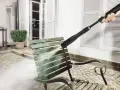 En Kärcher K5 rengör en smutsig grön parkbänk utomhus.