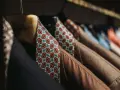 Un guardaroba elegante con giacche marroni e camicie dal tessuto dalle tinte diverse e vivaci, con fantasie geometriche.