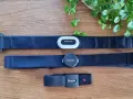 Tre pulsbands från Garmin, Suunto och Polar ligger på ett trägolv. Jämför garmin pulsband skillnad med de andra.