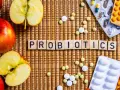 Äpfel und Pillen umgeben das Wort "PROBIOTICS". Eine natürliche Methode, probiotika gegen akne zu finden.