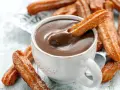 Ein Churro-Rezept zum Genießen: Knusprige Churros werden in heiße Schokolade getunkt.