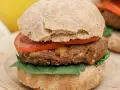 Hamburguesa de legumbres con pan integral, tomate y espinacas.
