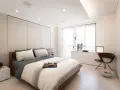 Camera da letto moderna con letto king-size, pannelli imbottiti e soffitto con faretti e strisce led controsoffitto che creano un'atmosfera rilassante.