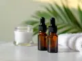 Dwa brązowe flakoniki z pipetką i słoiczek z kremem, obok biały ręcznik. Zastanawiasz się, czy serum można stosować codziennie?