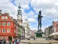Rynek w Poznaniu z fontanną i kolorowymi kamienicami.