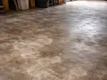 Pavimenti in cemento con macchie chiare, forse residui di acido muriatico dopo la pulizia.