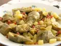 Plato de alcachofas tiernas y trocitos de jamón serrano, un clásico delicioso.