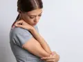 Mujer con dolor de codo, su piel con textura granulada se ve tensa.