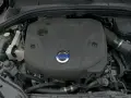 Silnik D4 Volvo pod czarną osłoną z niebieskim logo. Widać fragmenty przewodów i zbiornik płynu.