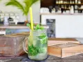 Erfrischender Mojito mit Minze und Eis in einem Glas. So trinkt man Rum an einem heißen Tag.