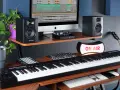 M-Audio Keystation 61, monitory studyjne, komputer z programem do produkcji muzyki, gitara i lampa "ON AIR" tworzą profesjonalne studio.