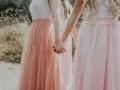 Dziewczyny w tiulowych, pudrowych sukienkach trzymają się za ręce. Ich styl to kwintesencja "soft girl".