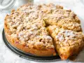Ein goldbrauner Apfelkuchen mit Streuseln, bestäubt mit Puderzucker. Dieses Apfelkuchen Rezept sieht köstlich aus!