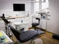Nowoczesny gabinet stomatologiczny z fotelem, unitem i ekranem.