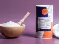Holzschale mit weißem Konjakmehl und Löffel daneben, eine Dose mit der Aufschrift "Konjakmehl" und Produktinformationen.