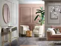 Un salotto elegante con pareti rosa antico e oro, divano in velluto, poltrone soffici e un tavolino in legno.