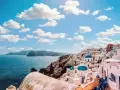 Santorini, Grecja. Ile się leci do raju? Białe domki z niebieskimi kopułami na tle błękitnego morza i nieba.