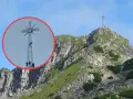 Ludzie wspinają się na krzyż na Giewoncie. Czy krzyż na Giewoncie świeci? Widać go z daleka na tle błękitnego nieba.