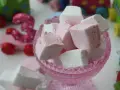 En skål med hemmagjorda marshmallows i rosa och vitt. I bakgrunden syns färgglada träleksaker, som en rosa bil med siffran 3.