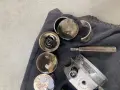 Zużyte popychacze hydrauliczne i inne części silnika pokryte olejem, gotowe do wymiany.
