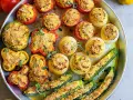 Vassoio di verdure ripiene al forno: pomodori, peperoni, cipolle e zucchine, dorate e profumate.