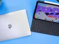 Geschlossenes MacBook neben einem geöffneten iPad Pro mit Tastatur und Apple Pencil.