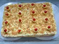 Rechteckiger Frankfurter Kranz Kuchen, bestreut mit gehackten Nüssen und verziert mit Sahnetuffs und Kirschen. Sally liebt diese Schnitten!