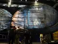 Scena teatralna z wielką, szklaną rybą, w której siedzi człowiek. To może być cud Jonasza.