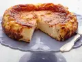 Tarta de queso La Viña, dorada y cremosa, servida en un plato morado.