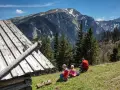 Rodzina odpoczywa na zielonej hali, podziwiając majestatyczne Tatry. Idealne tatry szlaki dla średnio zaawansowanych, z widokiem na góry i las.
