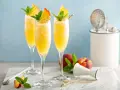 Orzeźwiający drink z prosecco i sokiem pomarańczowym, udekorowany brzoskwinią i miętą. Idealny na letnie popołudnie.