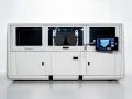 Nowoczesna maszyna do druku 3D, wykorzystująca technologię binder jetting, z panelem dotykowym prezentującym proces budowy.