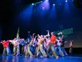 Tancerze na scenie, w ruchu, jakby tworzyli choreografię na żywo. To właśnie improwizacja co to – spontaniczność i kreatywność w tańcu.