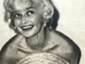 Uśmiechnięta Marilyn Monroe, ikona kina, w czarno-białym ujęciu. Jej imię zna cały świat.