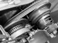 Zbliżenie na mechanizm bezstopniowej skrzyni biegów z widocznym pasem i kołami pasowymi.