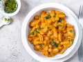 Herzhaftes Pasta e Ceci mit Kichererbsen in cremiger Sauce, garniert mit frischer Petersilie. Daneben eine kleine Schale mit Kräuteröl.