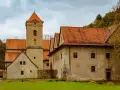 Czerwony Klasztor w Pieninach z wieżą zegarową i pomarańczowymi dachami.