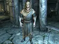 Un personaje con túnica y capucha en Skyrim, listo para curar el vampirismo.