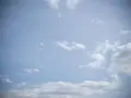 Jasne niebo z chmurami, efekt winietowania przyciemnia brzegi kadru, tworząc wrażenie głębi.