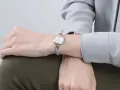 Delikatny zegarek na chudym nadgarstku, podkreślający elegancję.