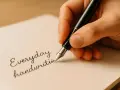 En hand håller en reservoarpenna och skriver "Everyday handwriting" på ett papper. Visar hur man håller en penna för vacker handstil.