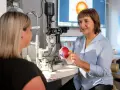 Augenarzt erklärt Modellauge. Mögliche Behandlung: Augen lasern. Krankschreibung wird besprochen.