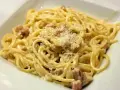 Pyszne spaghetti carbonara z kawałkami guanciale i startym parmezanem. Idealny ser do carbonary to klucz do sukcesu.