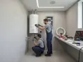 Tecnici controllano scaldino Chaffoteaux che non si accende. Attrezzi e tubi sul bancone.