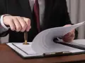 Prawnik pieczętuje dokumenty dotyczące podatku od spadku po rodzicach.